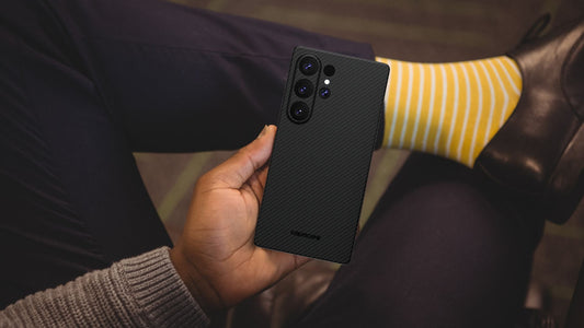formal dressed man in yellow striped socks holds Galaxy S25 ultra in hand, using aramid fiber phone case cover
