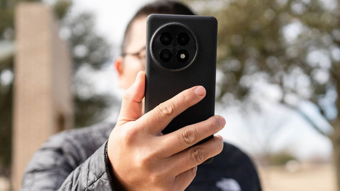 man holding oneplus 13 with a fiberborne case